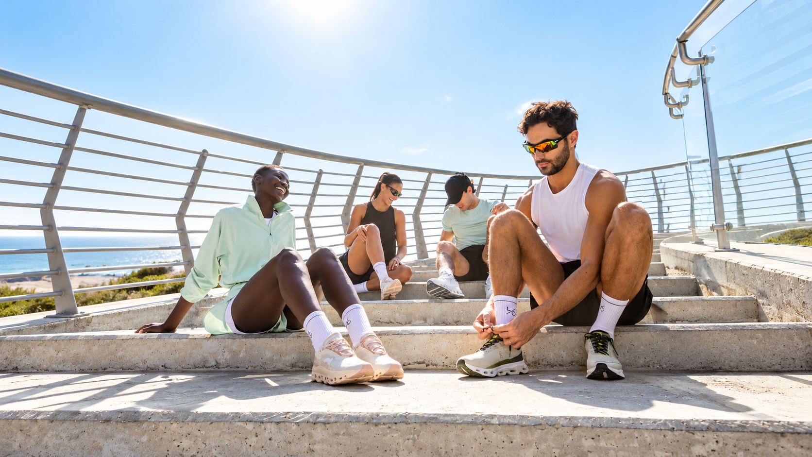 Friends resting on seaside stairs after a workout